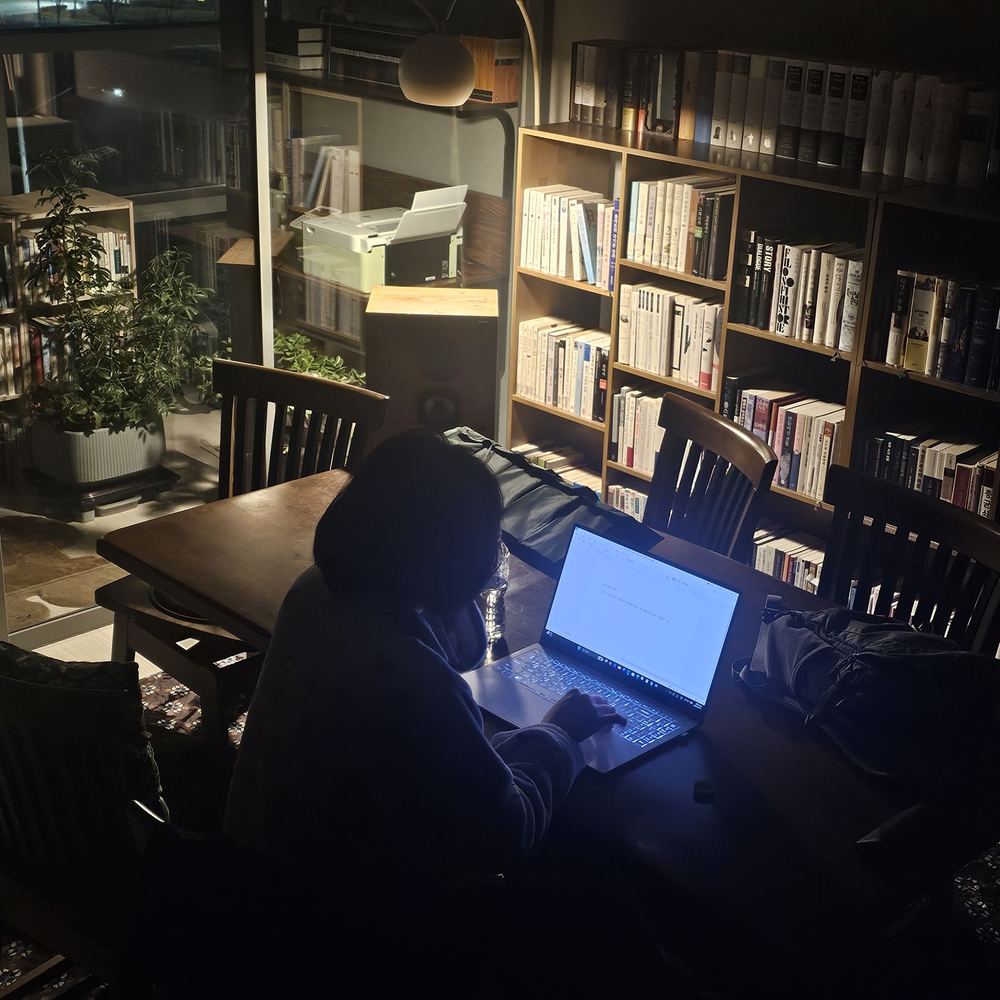 밤, 등불 아래에서 노트에 글을 쓰는 손