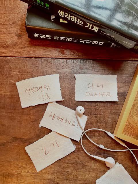 나무 책상 위, 손으로 찢은 종이에 쓴 언브랜딩 살롱·디퍼·함께해요